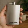 Silberner Flachmann mit Namensgravur Gebürsteter Edelstahl-Flachmann in Silber mit der Beispielgravur Hermann