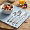 Kinderbesteck mit Superheldenmotiven Personalisiertes Kinderbesteck mit vier Superheldenmotiven auf einer blauen Serviette