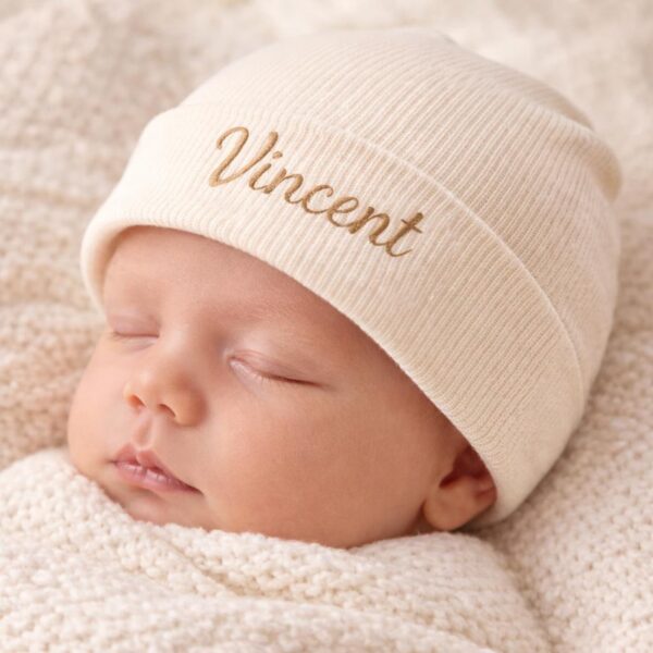 Schlafendes Baby mit cremefarbener gerippter Mütze und goldener Namensstickerei Vincent