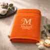 Orangefarbenes Handtuch mit weißem Monogramm und Namensstickerei Michael